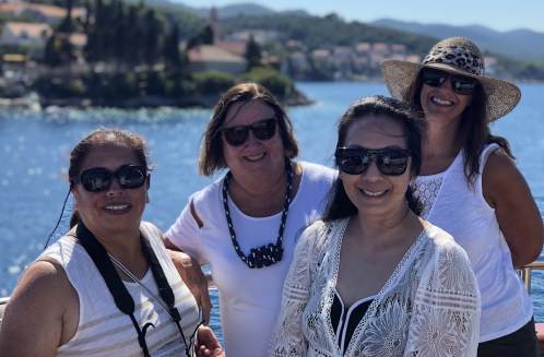 Small ship cruising along the Adriatic coast of Croatia with scenic coastal towns in view.